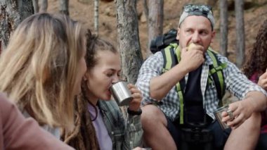 Bir grup arkadaş turist, sonbahar günü ormanda yiyip içip dinleniyorlar.