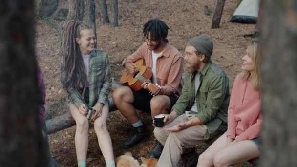 Afro-amerikansk man spelar gitarr medan vänner turister sjunger och skrattar i skogen — Stockvideo