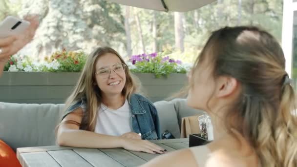 Jovens senhoras alegres conversando com garçonete pedindo comida no café ao ar livre no verão — Vídeo de Stock