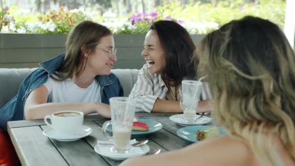 Портрет веселых дам, разговаривающих смеющихся и пьющих кофе, расслабляющихся в кафе под открытым небом — стоковое видео