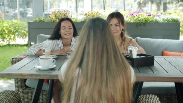 Портрет красивых девушек друзей, общающихся в городском уличном кафе летом — стоковое видео