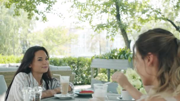 Joyeux jeune femme bavarder avec des amis dans un café en plein air, puis payer avec une carte bancaire souriant à la serveuse — Video