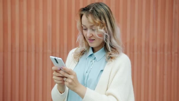 快乐的女人带着智能手机发短信，微笑着享受户外交流 — 图库视频影像