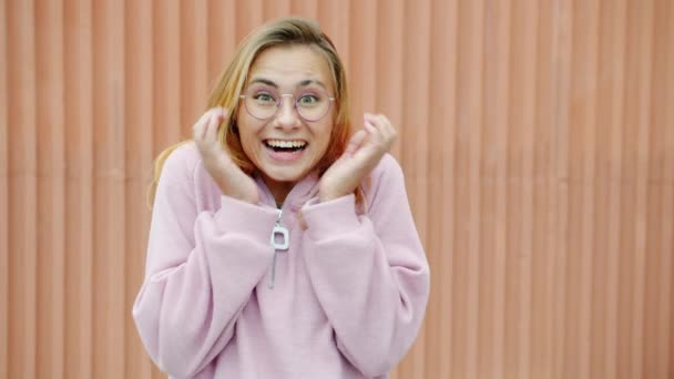 Porträtt av förvånad och upphetsad flicka som uttrycker lycka stående utomhus ensam — Stockvideo