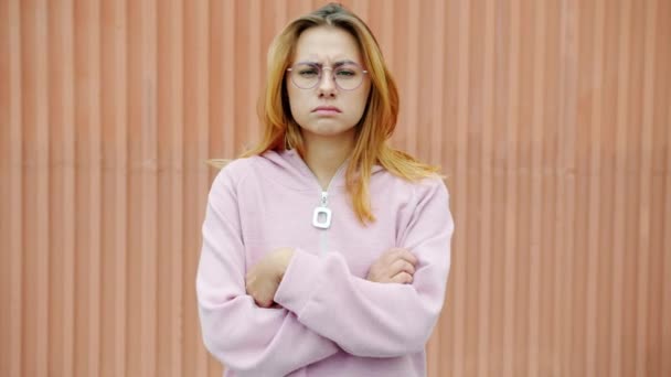 Zeitlupe Porträt einer unglücklichen und beleidigten Frau, die die Arme verschränkt und im Freien in die Kamera blickt — Stockvideo