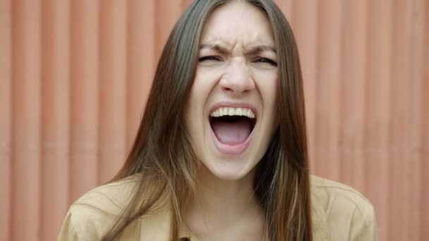 Close-up portrait of stressed girl screaming and looking at camera standing outdoors in summer — Stock Video