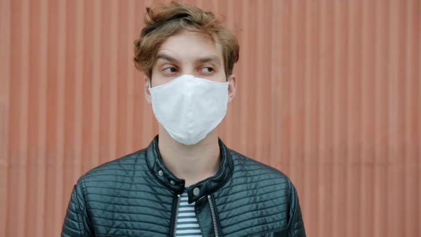 Portret van een man die een medisch masker afdoet en ademt genietend van de frisse lucht en dan weer optrekt — Stockvideo
