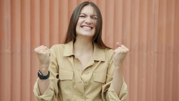 Retrato de jovem excitada levantando punhos desfrutando de sucesso e realização ao ar livre — Vídeo de Stock