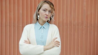 Çekici, hırslı bir kızın yavaş çekim portresi. Ciddi bir yüzle kameraya bakıyor ve açık havada gülümsüyor.