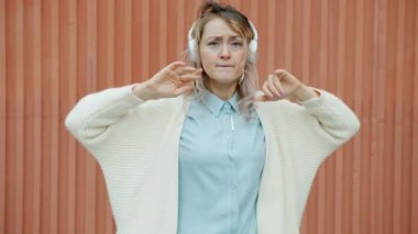 Yavaş çekimde, kulaklıklı, dans eden, hareketli vücutlu, yaratıcı bir kadının portresi.