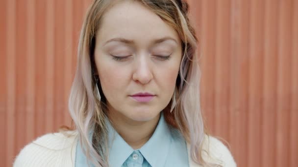 Gros plan portrait de dame paisible aux cheveux blonds debout à l'extérieur avec les yeux fermés — Video