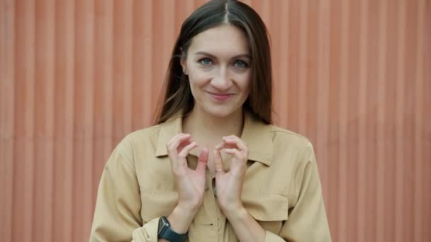 Portret van een opgewonden jongedame die handen wrijft met een slecht gezicht en glimlacht terwijl ze naar de camera kijkt. — Stockvideo