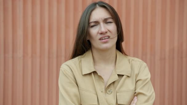 Retrato en cámara lenta de la joven aburrida bostezando mirando a la cámara de pie al aire libre — Vídeo de stock