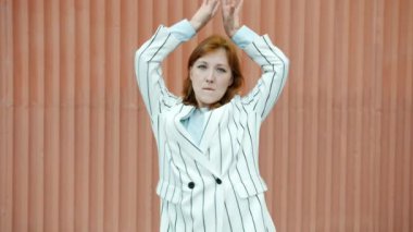 Dans eden güzel genç bir kadının ağır çekim portresi. Hareket eden vücut dışarıda eğleniyor.