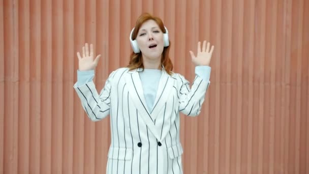 Zpomalený film portrét veselá zrzka dáma na sluchátka tanec venku — Stock video