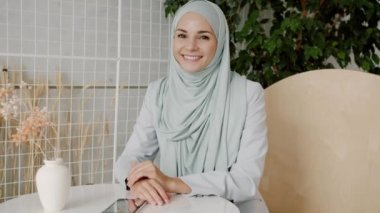 Kafede gülümseyen geleneksel tesettüre sahip güzel müslüman kadın portresi