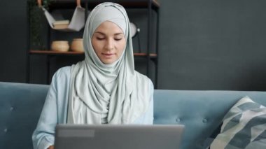 İş kadını portresi tesettürlü evde çalışan bilgisayarlı uzak işten zevk alıyor.
