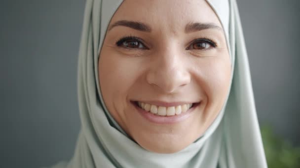 Close-up portret van aantrekkelijke gemengde ras dame dragen hijab glimlachen binnen — Stockvideo