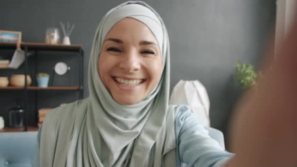 POV-Porträt einer attraktiven muslimischen Frau, die spricht und gestikuliert, wenn sie zu Hause ein Online-Videotelefon führt — Stockvideo