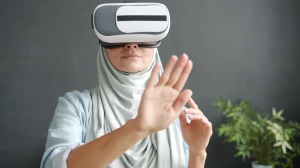 Potret gadis hijabi mengenakan kacamata bergerak tangan menikmati pengalaman virtual di dalam ruangan di rumah — Stok Video