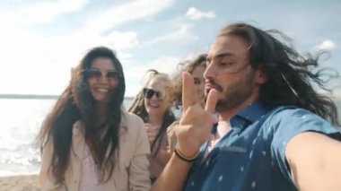 Plaj partisi sırasında çok ırklı arkadaş grubuyla dans eden çekici bir Arap 'ın portresi.