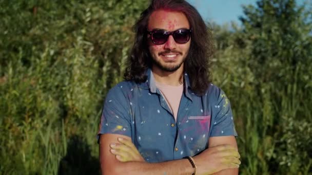 Zpomalený film portrét usměvavého Araba těší Holi festival, zatímco lidé házejí malířský prášek na něj — Stock video