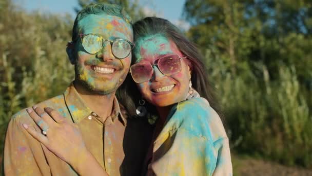 Mand og kone dækket med farverig maling smilende nyder Holi festival udendørs – Stock-video