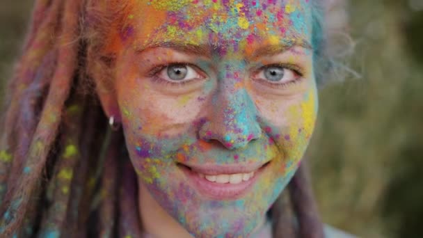 Primer plano retrato de la joven creativa con la cara colorida y temores sonriendo fuera — Vídeo de stock