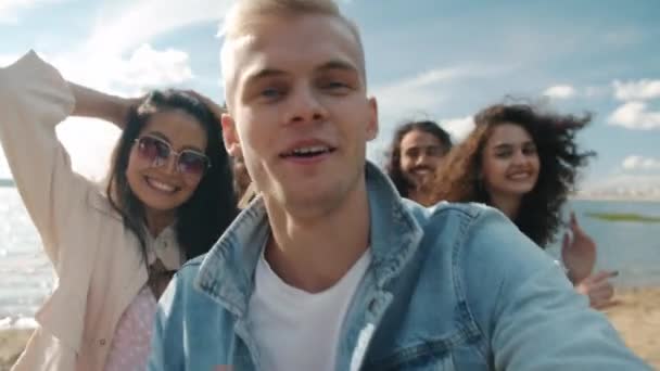 Porträtt av glad blond kille dansar utomhus sjunga ha kul med blandade ras vänner — Stockvideo