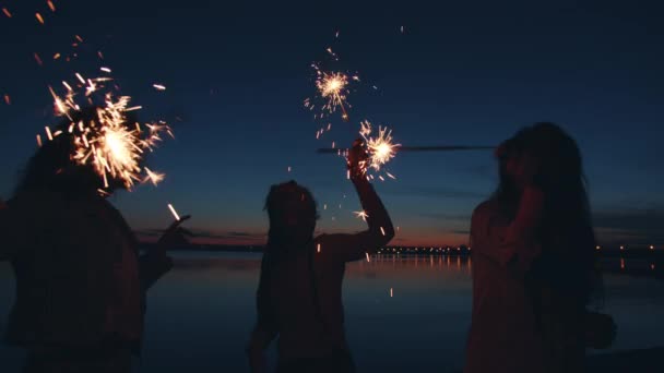 Gece açık hava partisinde sahilde dans eden mutlu genç kadınların yavaş çekimleri. — Stok video