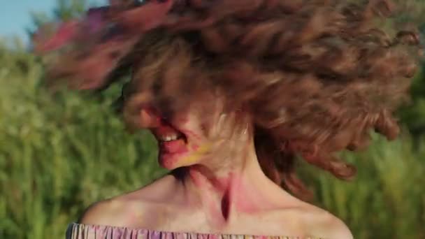 Zpomalení pohybu krásné dívky mává vlasy pokryté gulální barvou na festivalu Holi — Stock video
