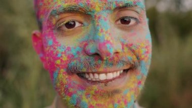 Holi Festivali 'nde boyalı yüzü olan yakışıklı bir Arap' ın yavaş çekim portresi.