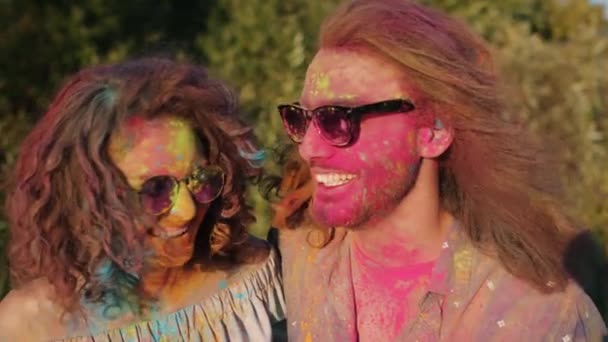 Mutlu Asyalı kadın Holi festivalinde boya tozuyla kaplı mutlu çifte sarılıyor. — Stok video