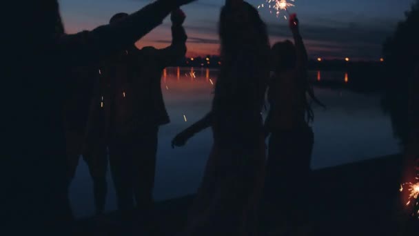Geceleri açık hava kumsal partisinde açık hava ışıklarıyla dans eden şakacı kızlar ve erkekler. — Stok video