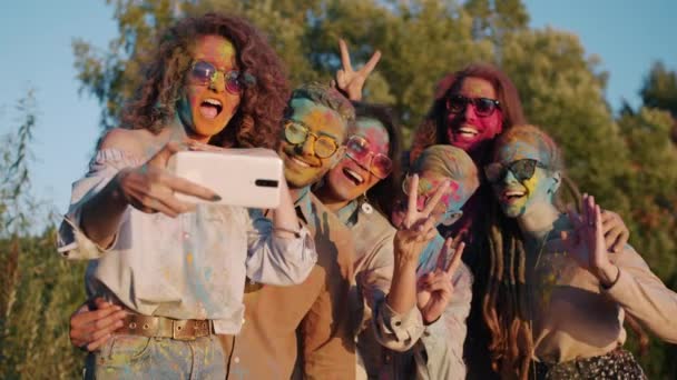 Glad ungdom som tar selfie med smartphone kamera poserar med målade ansikten under Holi firandet — Stockvideo