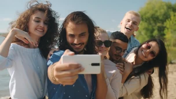 Groupe multi-ethnique d'amis prenant selfie avec téléphone intelligent posant sur la plage en été — Video