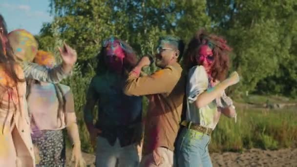 Opgewonden mannen en vrouwen bedekt met poeder verf dansen plezier hebben op Holi feest — Stockvideo