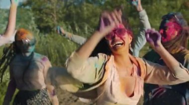 Dans eden ve boya fırlatan çok ırklı bir arkadaş grubu Holi kutlamasının tadını çıkarıyor.