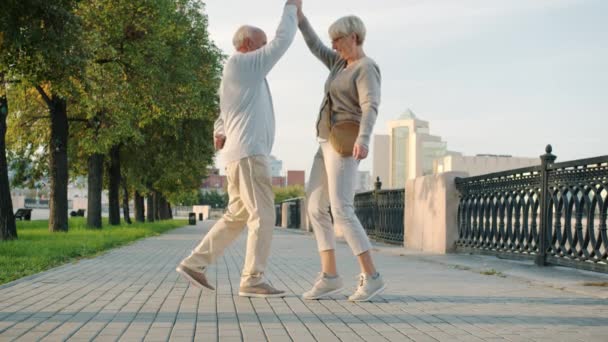 Slow motion van vrolijk getrouwd stel gepensioneerden dansen glimlachen plezier in de stad straat — Stockvideo