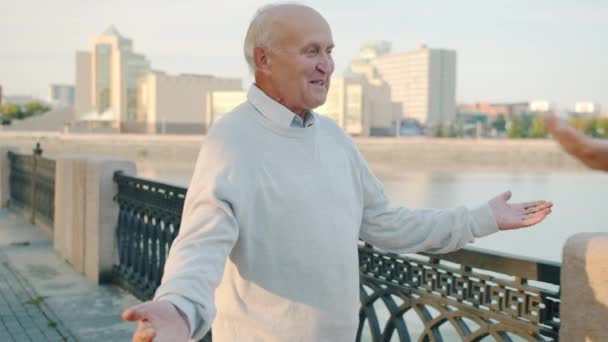 Senior Mann und Frau treffen sich am Ufer des Flusses und umarmen sich Händchen haltend — Stockvideo