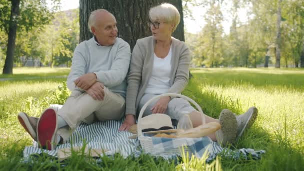 Zorgzame vrouw geven pillen aan senior man zorg voor gezondheid tonen duimen-up tijdens de picknick in het park — Stockvideo