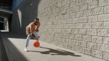 Kentsel caddede basketbol oynayan Afrikalı Amerikalı adamın sonsuz döngüsü.