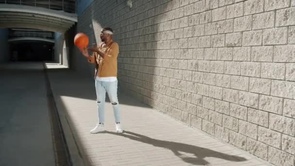 Loop πορτρέτο του χαρούμενου Αφροαμερικανού μπασκετμπολίστα διασκεδάζοντας με μπάλα σε εξωτερικούς χώρους — Αρχείο Βίντεο
