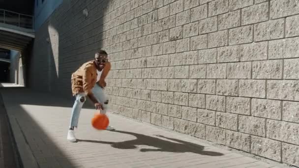 도시의 거리에서 축구를 하고 있는, 스포츠를 좋아하는 아프리카 계 미국인 남자의 끝없는 고리 — 비디오