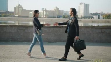 İş adamı ve kadın halkaları dışarıda el sıkışıyor.
