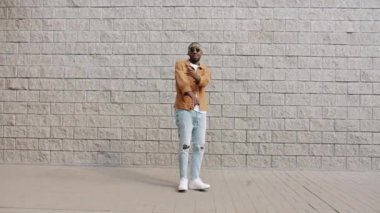 Duvarın arkasında dans eden ve el kol hareketi yapan duygusal Afrikalı Amerikalı adamın portresi.