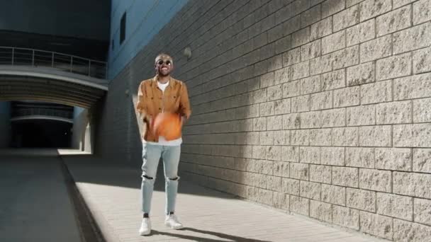 Loop portrét veselý afroameričan házet a chytat basketbal venku — Stock video
