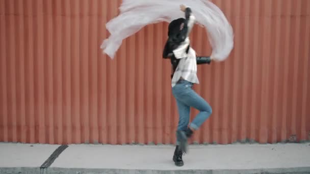 Retrato de niña feliz bailando con lámina de polietileno ondeando en el aire divirtiéndose contra el fondo de la pared — Vídeos de Stock
