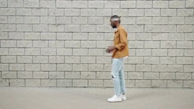 Beyaz arka planda robot dansı yapan komik Afro-Amerikalı adamın yan görünümü
