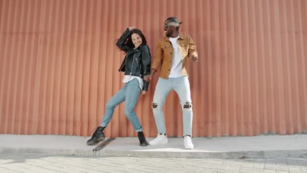 Boucle de danse de jeunes artistes couple dansant en plein air en s'amusant sur fond de mur — Video